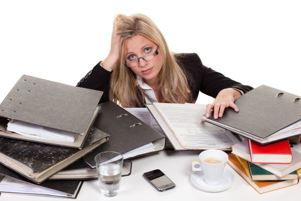 Woman struggling on papers, books and work