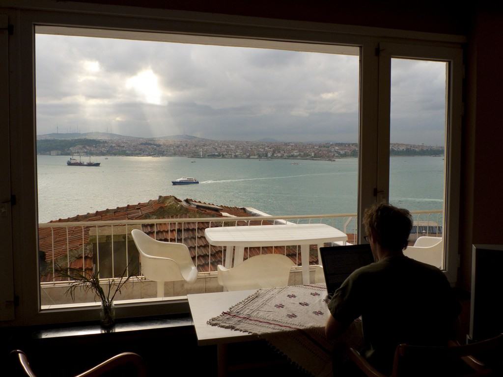 A guy working with laptop with amazing view on window